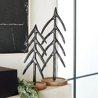 Stylized metal Christmas tree sculptures on wooden bases, featuring intricate branching forms