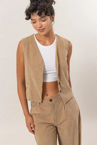 Tan corduroy vest over white crop top and high-waisted pants from Shop Daisy’s womens boho clothes