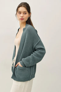 Teal chunky knit drop shoulder cardigan with textured knit, hood, and drawstring pockets