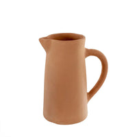 Unglazed terracotta pitcher with cylindrical shape and curved handle for boho decor