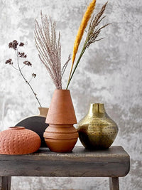 Terracotta vase with dried grasses in a Hammered Metal Finish Vase for elegant decor