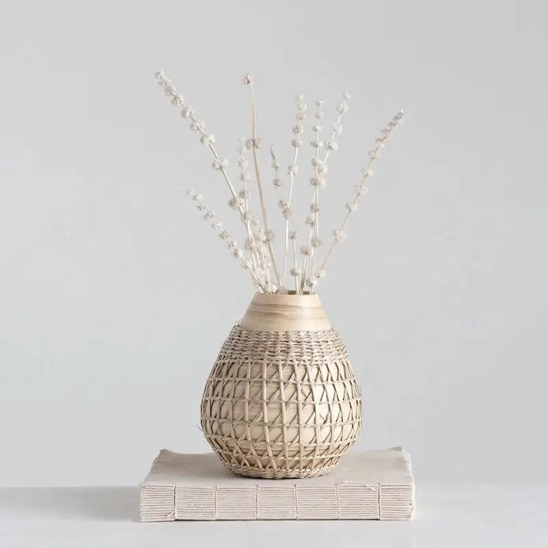 Textured beige ceramic vase with geometric patterns and dried flowers for boho chic decor