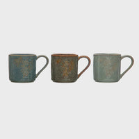 Three embossed stoneware mugs featuring elegant leaf designs on their surfaces