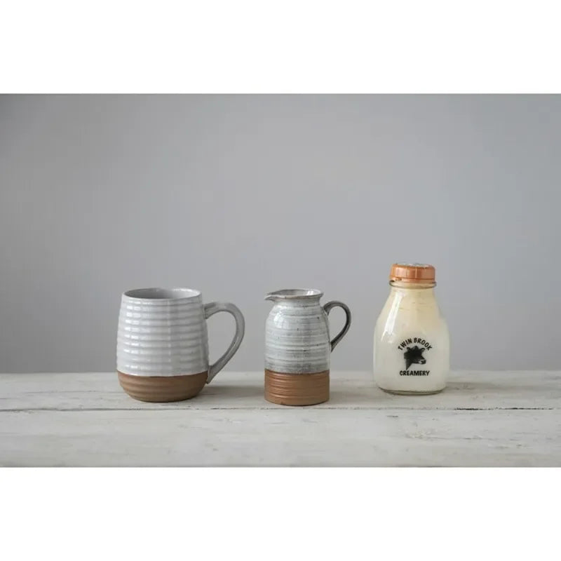 Three ceramic vessels showcasing a Stoneware Creamer with Reactive Glaze and boho chic aesthetics