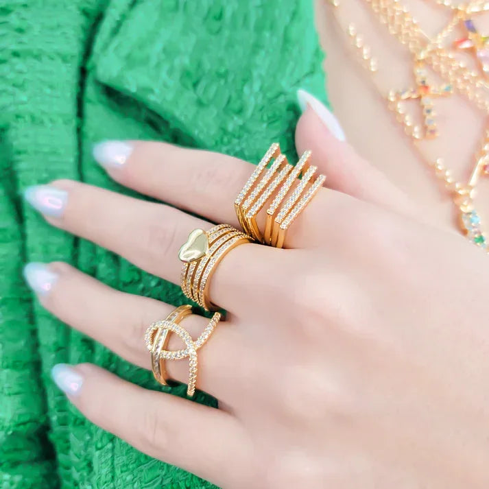 Three gold rings with clear gemstones on fingers, showcasing the LOOPED CZ RING ADJUSTABLE GOLD RING