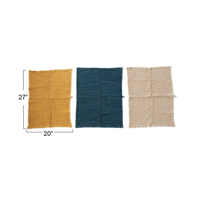 Three waffle-textured tea towels in yellow, teal, and beige for a boho kitchen