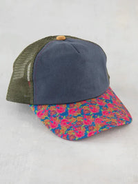 Trucker hat with navy front, olive mesh, and colorful floral brim in boho style