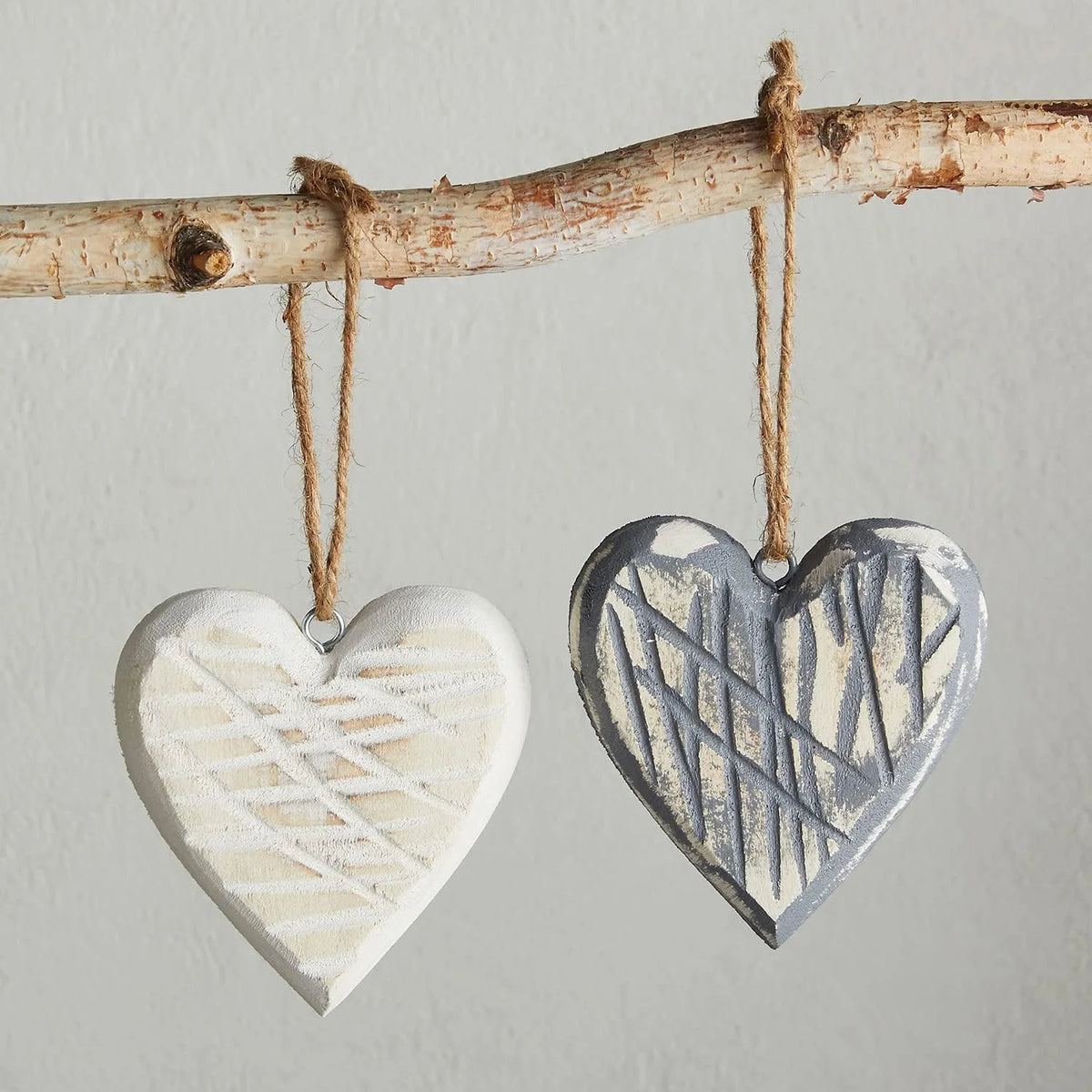 Two textured heart ornaments on a birch branch, perfect for women’s boho chic clothing by Shop Daisy