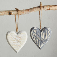 Two textured heart ornaments on a birch branch, perfect for women’s boho chic clothing by Shop Daisy