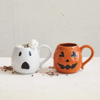 Two Halloween-themed stoneware ghost shaped mugs, one ghost and one jack-o’-lantern