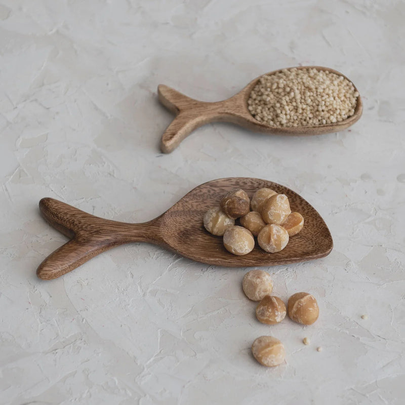 Two wooden spoons with nuts on an Acacia Wood Fish Shaped Dish, perfect for serving