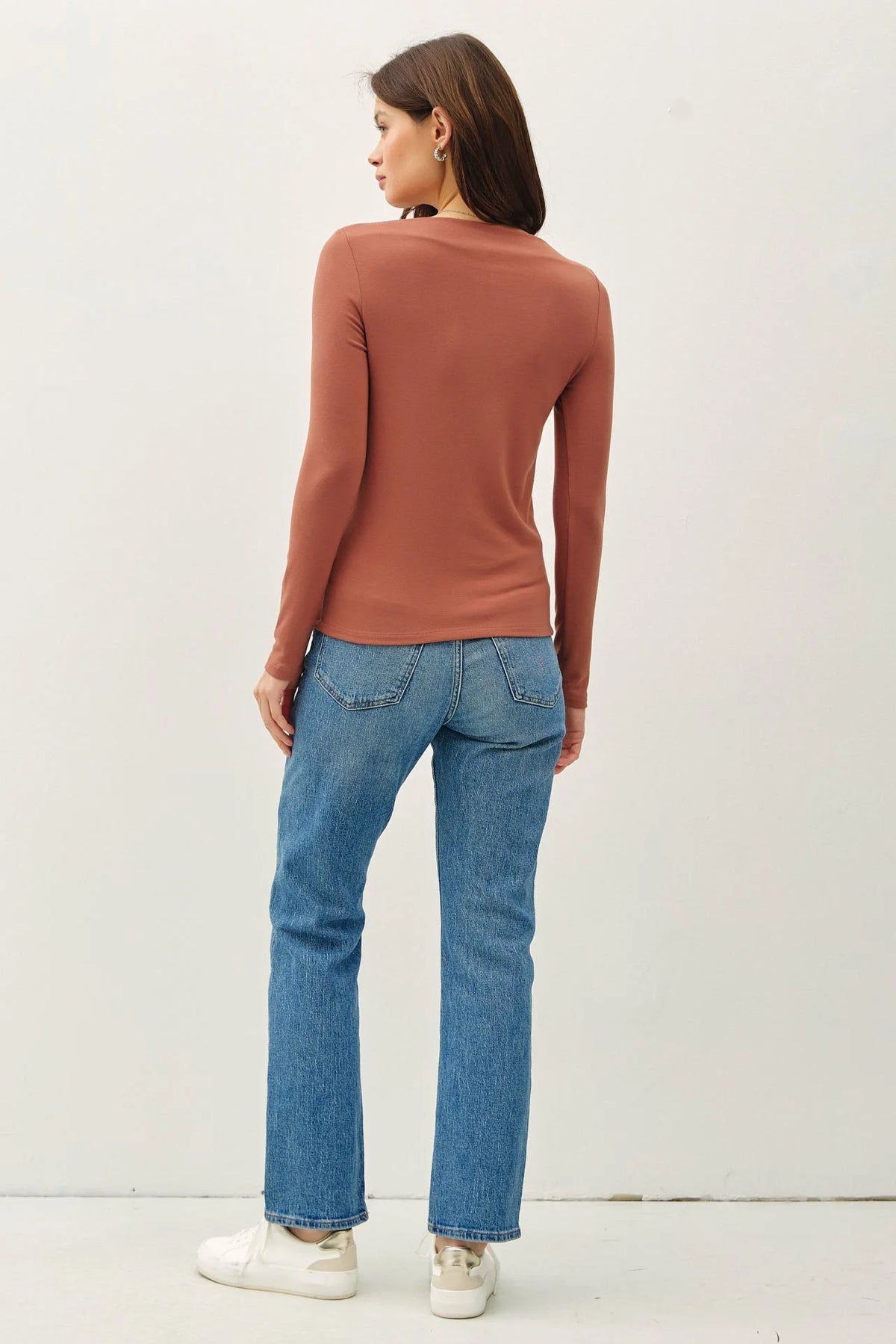 Back view of a person in a BASIC BOAT NECK LONG SLEEVE with blue jeans and sneakers