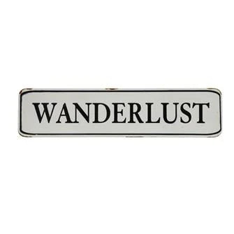 Wanderlist pin badge on a Wanderlust Sign for world travelers and boho enthusiasts