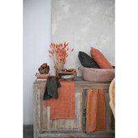 Weathered wooden cabinet with oversized stonewashed linen tea towel and decorative items