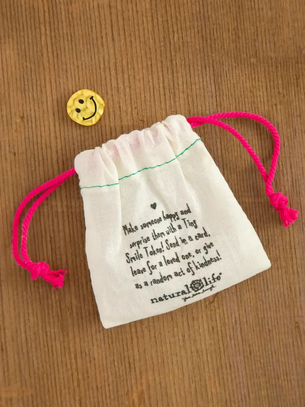 White drawstring bag with pink cords ideal for storing tiny tokens in women’s boho chic clothing
