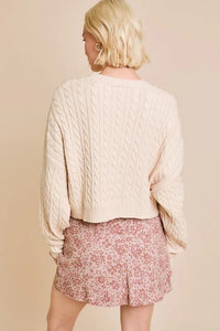 White dolman sleeve cable sweater top with pink floral shorts shown from behind