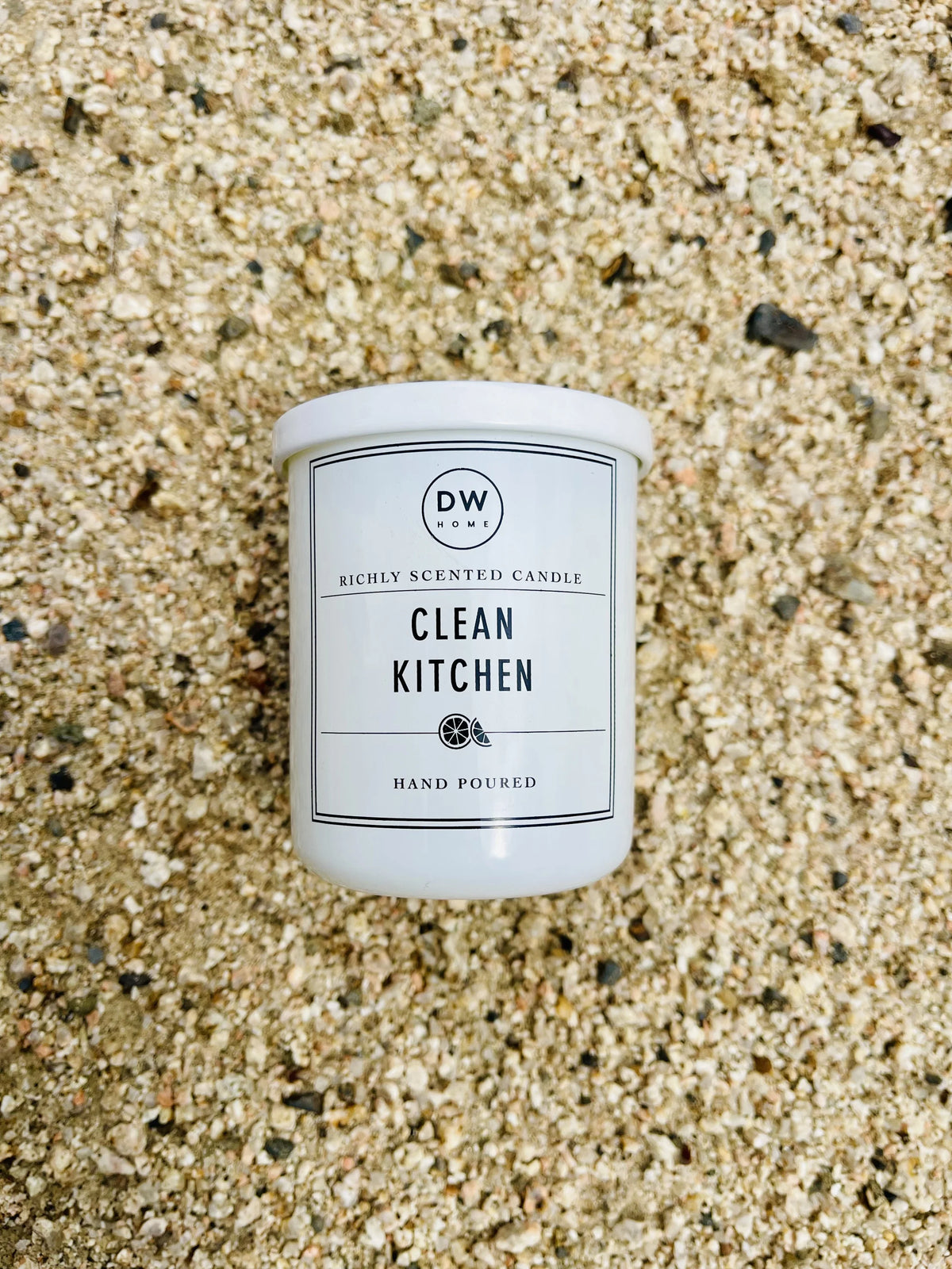 White candle on sandy beach featuring Clean Kitchen Mini with lime zest aroma