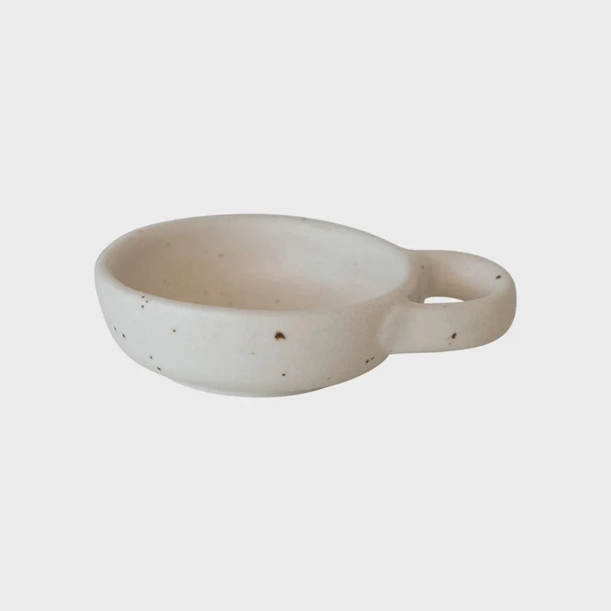 White ceramic stoneware dish with handle featuring a unique design and flowy style