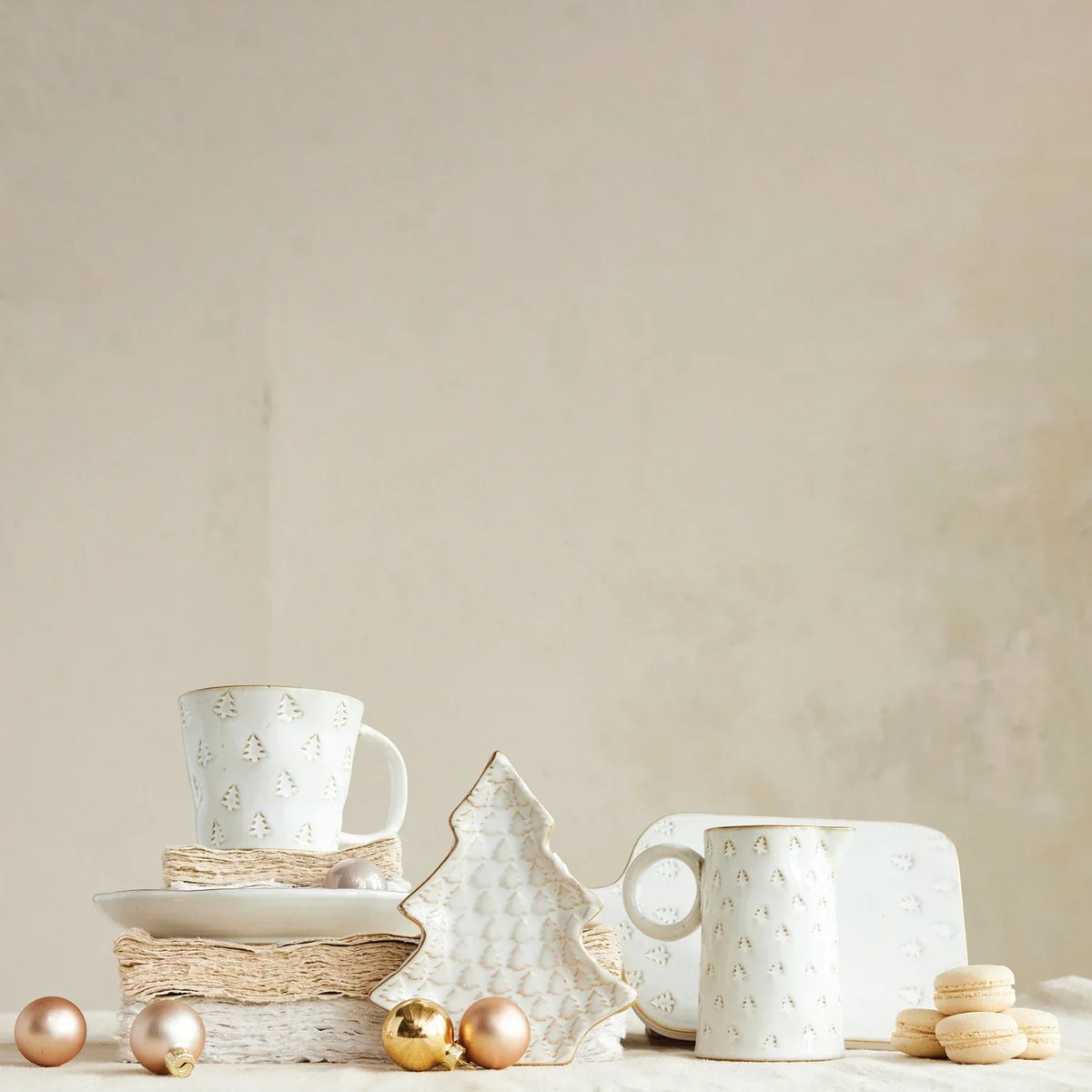 White ceramic debossed stoneware Christmas mug shaped like a Christmas tree with gold accents