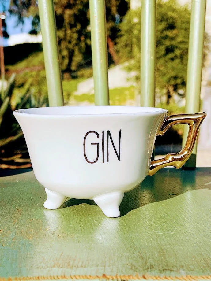 White stoneware footed teacup with GIN text and gold electroplated handle