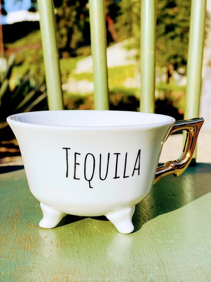 White stoneware footed teacup with TEQUILA design and small feet at the base