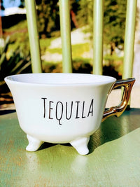 White stoneware footed teacup with TEQUILA design and small feet at the base