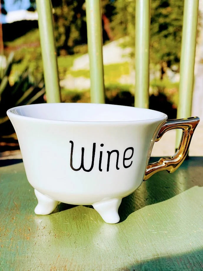 White ceramic stoneware footed teacup with ’Wine’ and a gold electroplated handle