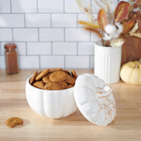 White ceramic pumpkin treat jar filled with delicious cookies for festive snacking