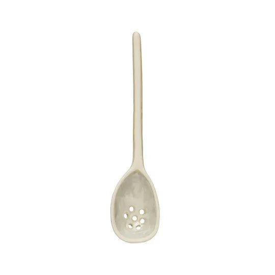 White ceramic slotted spoon with long handle, a stylish white stoneware strainer