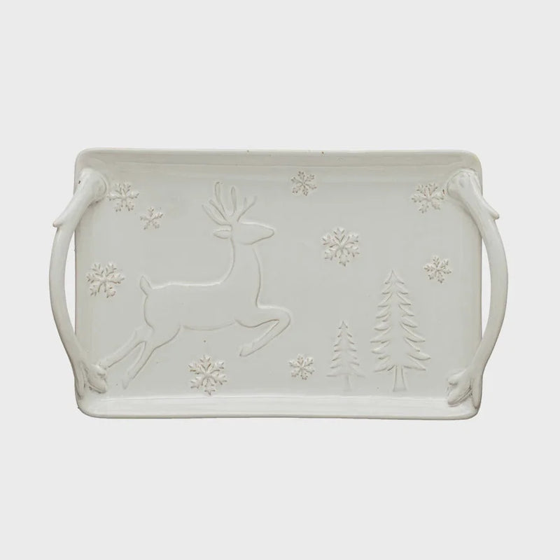 White ceramic serving tray with embossed winter scene of a reindeer, trees, and snowflakes