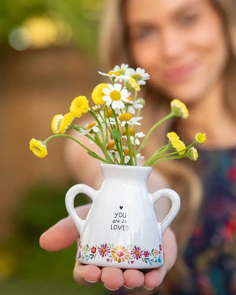 White ceramic artisan bud vase with handles featuring yellow and white flowers