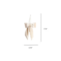 Velvet fabric bow with white cross, beige ribbon, and tassel