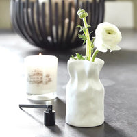 White crumpled ceramic vase with a ranunculus flower, ideal for women’s boho chic clothing