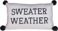 White decorative pillow with SWEATER WEATHER text and pom-poms for women’s boho chic clothing