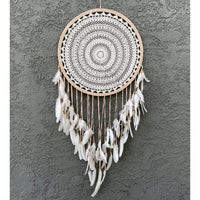 Elegant white dream catcher hanging on wall, ideal for repelling bad dreams in boho decor