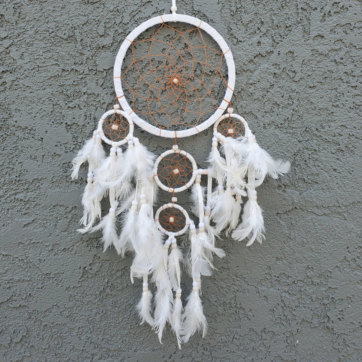 White small dream catcher elegantly displayed on a wall, enhancing decor and serenity