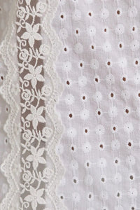 White eyelet fabric with floral lace trim showcases women’s boho chic clothing, shop Daisy