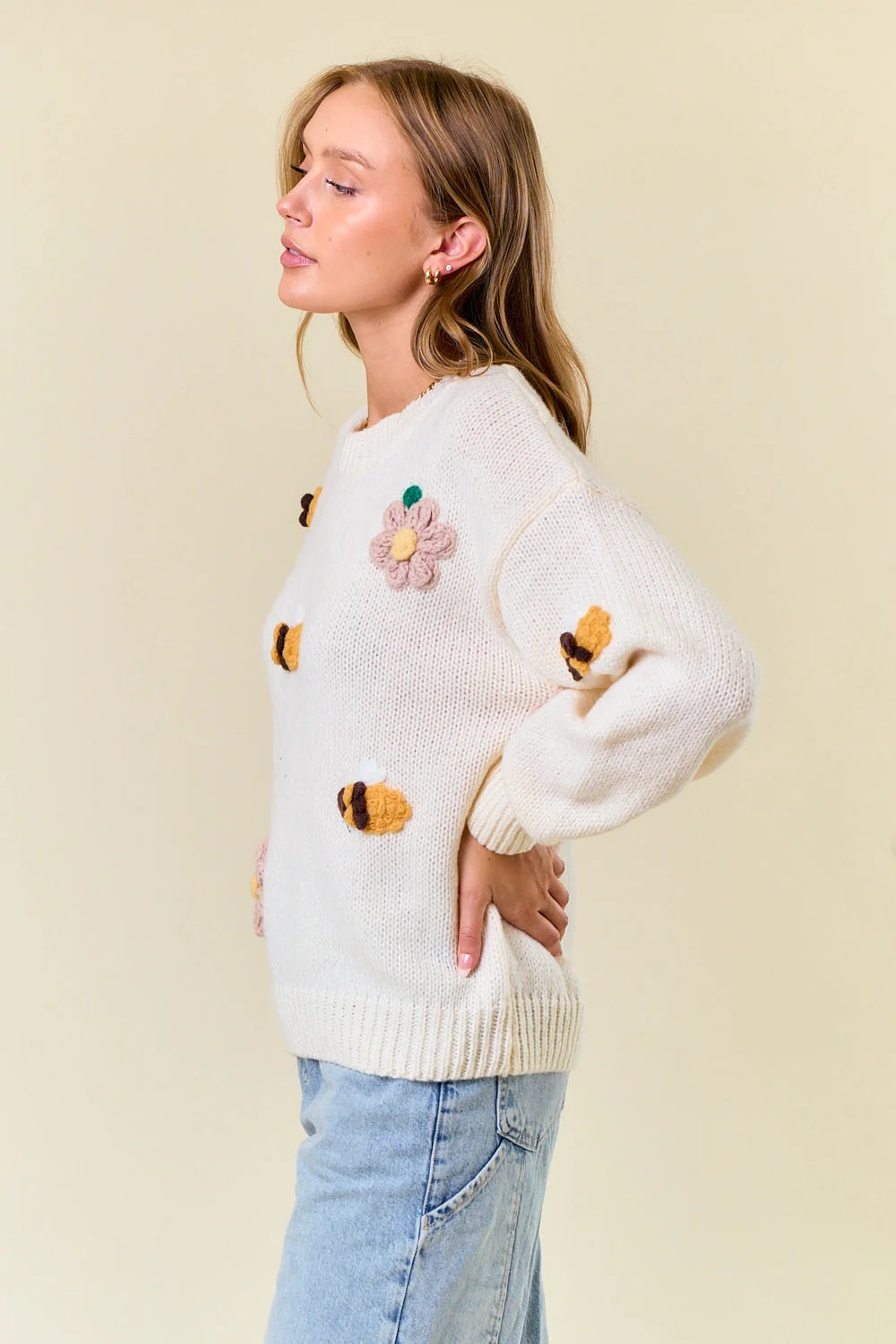 White fuzzy knit sweater for women, size small, featuring colorful bee and flower appliques