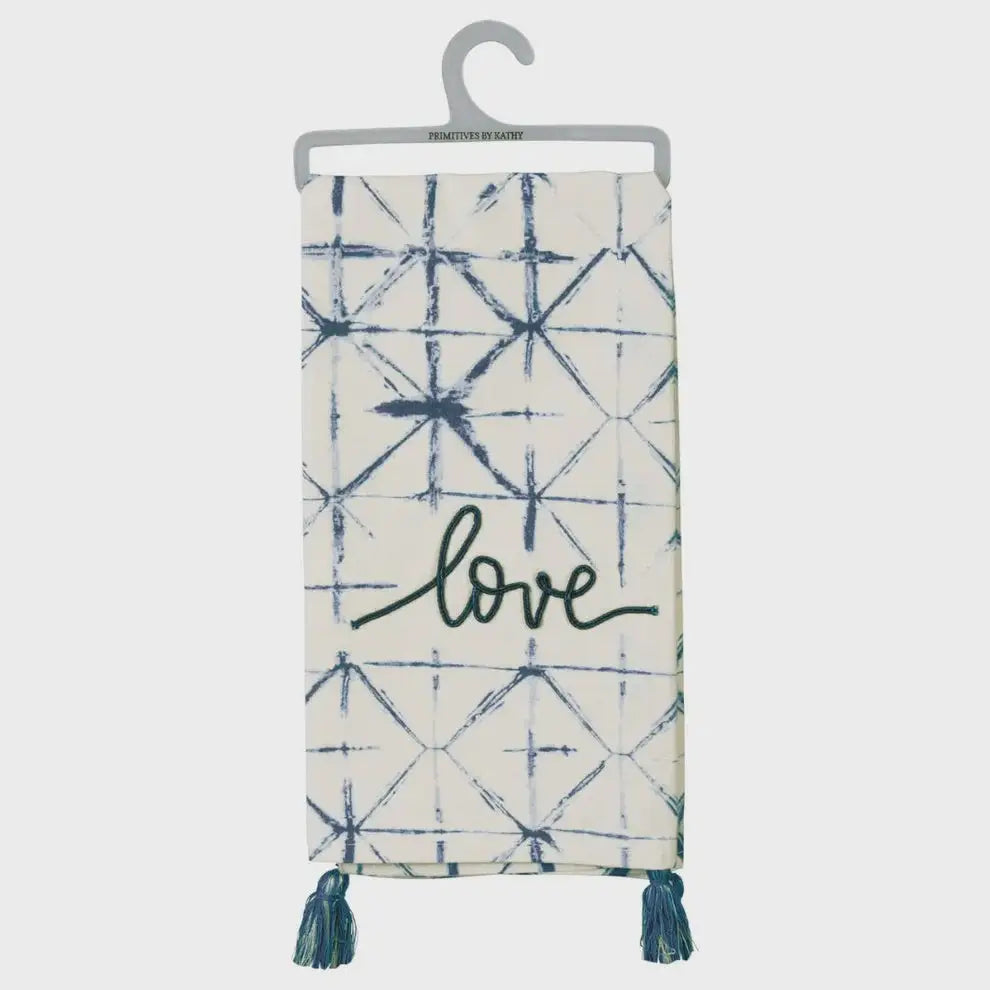 White kitchen towel with blue shibori pattern and dori stitched love, featuring tassel corner details