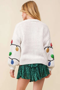 White knit sweater with pom-pom sleeves from the Christmas Sequin Light Cardigan