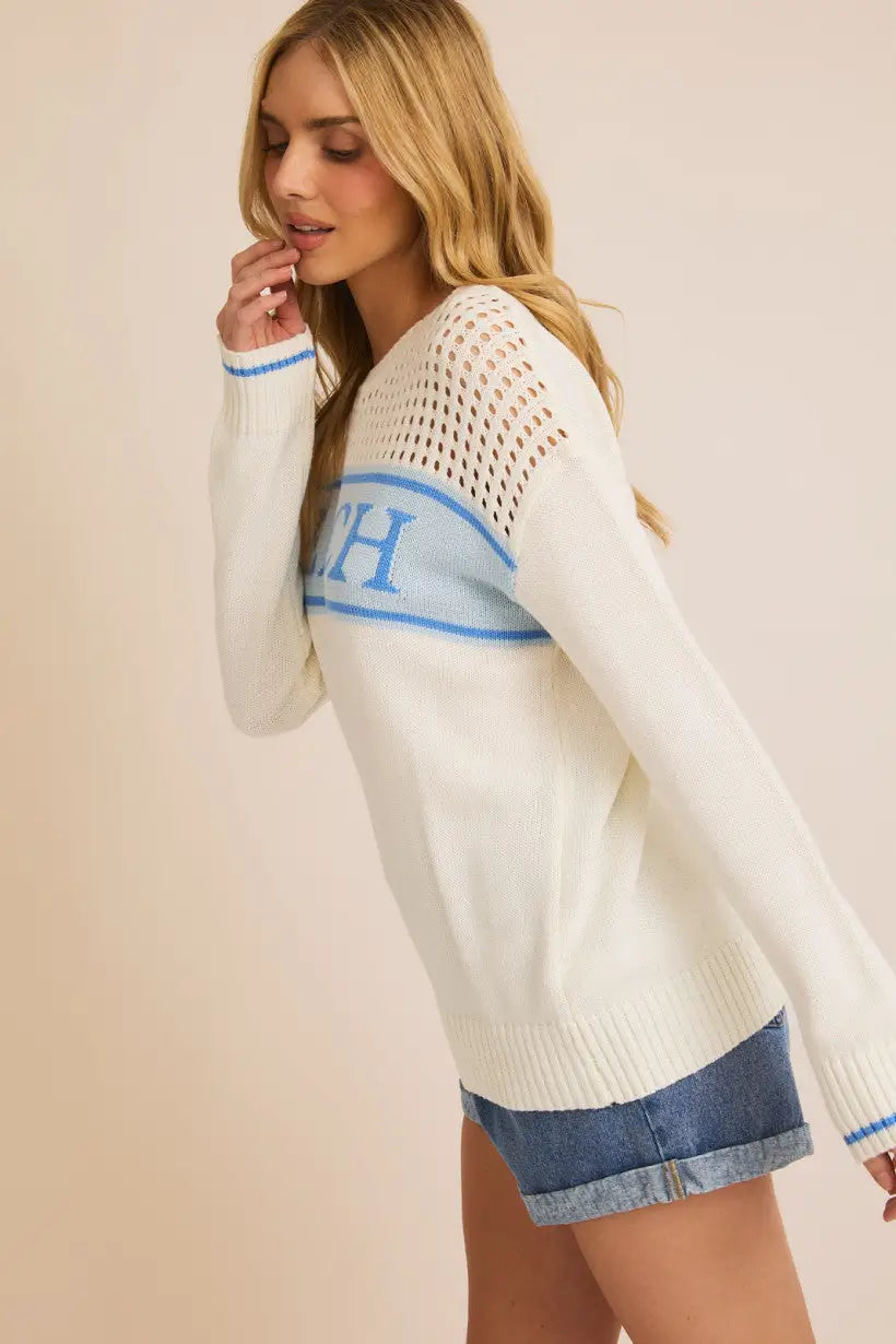 White knit sweater with blue accents, ideal lightweight women’s beach sweater