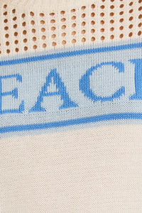 White knit sweater with blue lettering, a lightweight women’s beach sweater for style