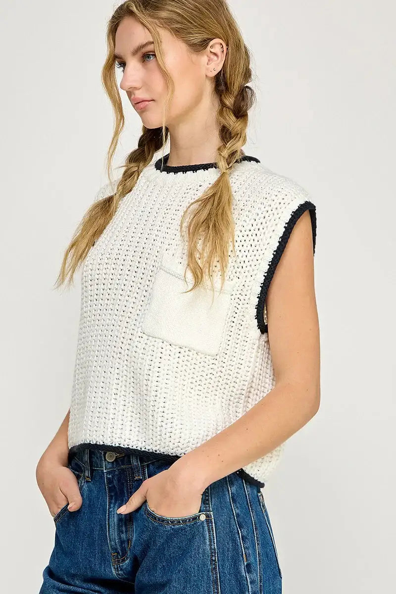 White knit vest with black trim from Shop Daisy, perfect for women’s boho chic clothing