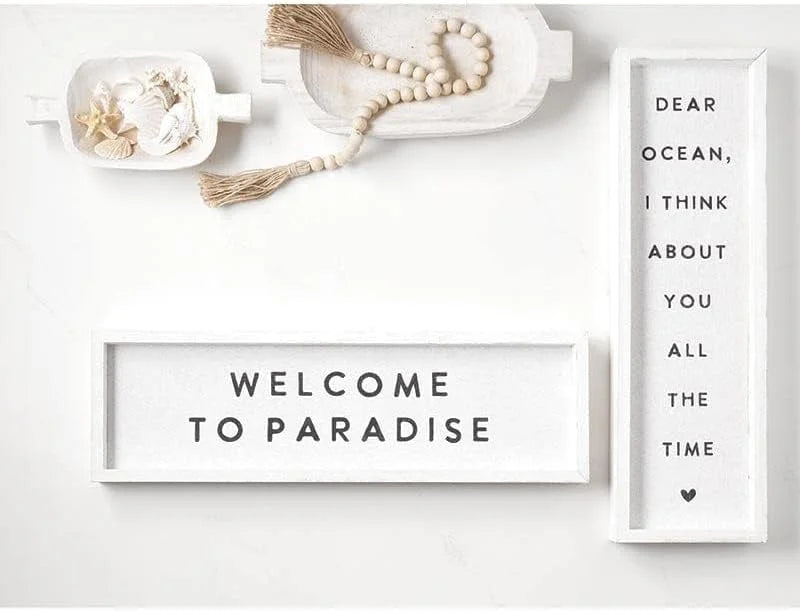 White letterboard wall art that reads WELCOME TO PARADISE, enhancing coastal home decor