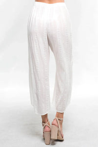 White linen wide-leg cropped pants styled with beige high-heeled sandals for a boho look