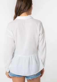 White bohemian long sleeve tiered blouse with button front worn with denim shorts