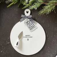 White ceramic cheese tray featuring a cutout tree design and Merry Everything text