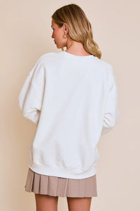 White oversized Cheers Graphic Sweatshirt paired with a pleated skirt for a stylish look