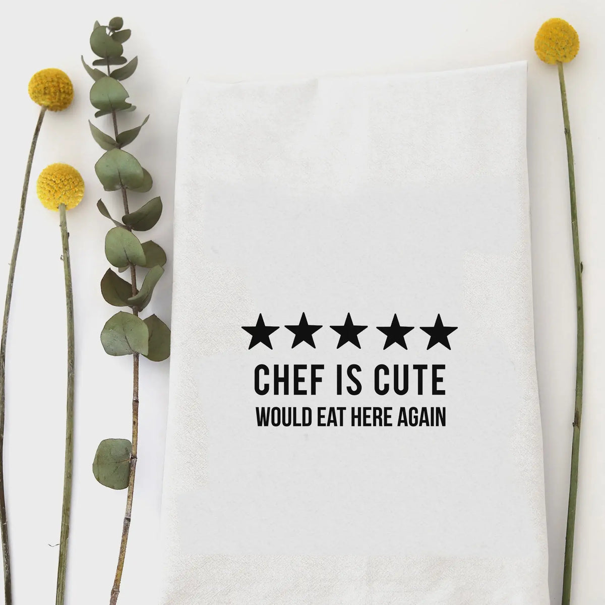 White kitchen tea towel featuring humorous text and five stars on flour sack fabric