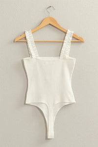 White ribbed ruffle strap bodysuit featuring stylish ruched detailing